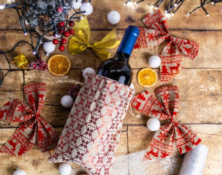 Photo for A top view of a bottle of wine on the wooden table decorated with Christmas ornaments - Royalty Free Image
