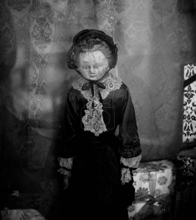 Téléchargez les photos : Une échelle de gris d'une poupée vintage devant un mur avec un motif ornemental - en image libre de droit