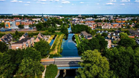 Photo for An aerial shot of a small bridge over a river with the Heerenveen town in the background - Royalty Free Image