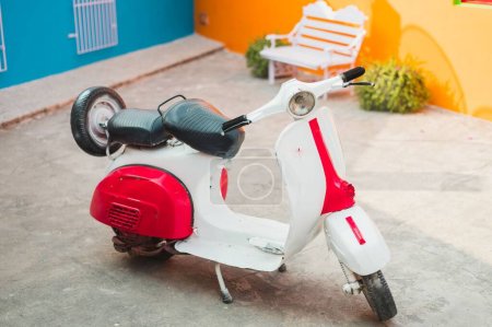 Téléchargez les photos : Un scooter Vespa vintage garé devant une maison - en image libre de droit