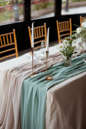 Téléchargez les photos : Un plan vertical d'une table joliment décorée avec des fleurs blanches et des bougies pour la fête de mariage avec des chaises - en image libre de droit