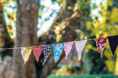 Photo for The view of colorful handmade triangular party decoration made of fabrics, hung outdoors - Royalty Free Image