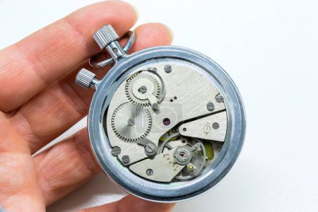 Foto de Un primer plano de una persona sosteniendo un viejo reloj de temporizador antiguo sobre un fondo blanco - Imagen libre de derechos