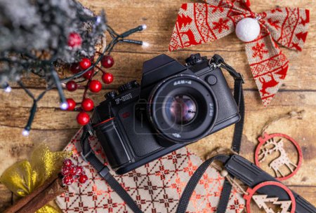 Photo for A top view of an old film camera on the wooden table decorated with Christmas ornaments - Royalty Free Image