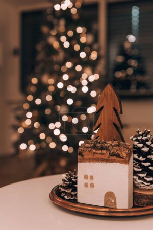 Téléchargez les photos : Plan vertical d'une décoration en bois sur le fond flou d'un arbre de Noël - en image libre de droit