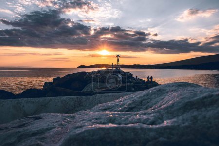 Paysage marin avec reflet du soleil sur de grands rochers et mer Égée calme dans l'île de Thasos, Grèce, belle ligne d'horizon orange au coucher du soleil
