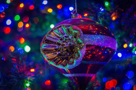 Téléchargez les photos : Un gros plan d'un jouet d'arbre de Noël avec des lumières lumineuses colorées sur le fond flou - en image libre de droit