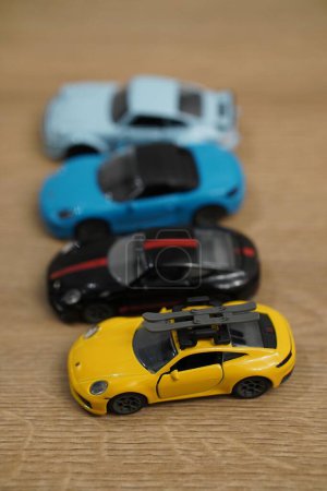 Téléchargez les photos : Un plan vertical de petits modèles Porsche de la marque Majorette sur une surface en bois - en image libre de droit
