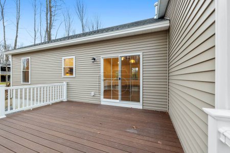 Téléchargez les photos : Une maison contemporaine et moderne de style ranch dans la banlieue, et son porche avec planches de terrasse et balustrades - en image libre de droit