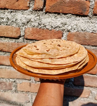 Foto de Chapati, también conocido como roti, rotli, safati, shabaati, phulka, chapo, poli y roshi. Usando harina de trigo hacer roti, en el plato, se utiliza el consumo diario en la India - Imagen libre de derechos