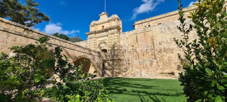 Téléchargez les photos : La porte de Mdina par une journée ensoleillée avec un ciel bleu nuageux en arrière-plan à Mdina, Malte - en image libre de droit