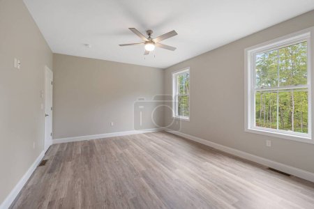 Foto de Un interior de una amplia habitación con paredes grises y parquet de estilo minimalista - Imagen libre de derechos