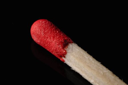 Photo for A macro shot of a wooden match, with red phosphorus on the top, on a black background - Royalty Free Image