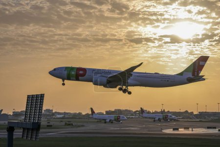 Foto de Vista lateral del avión TAP Air Portugal que sale del aeropuerto Humberto Delgado al atardecer - Imagen libre de derechos