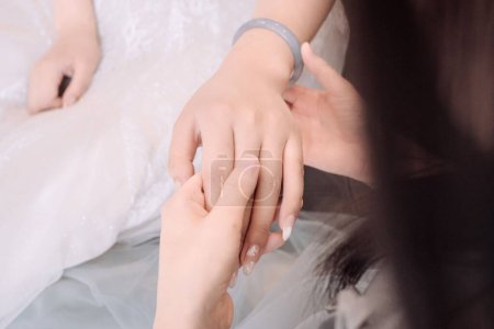 Foto de Una persona sosteniendo la mano de una novia en un vestido de novia blanco - Imagen libre de derechos