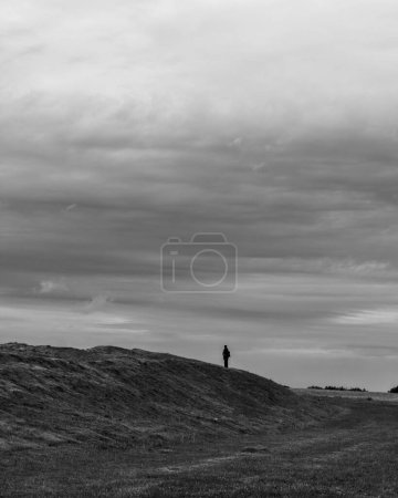 Photo for A black and white shot of a male walking in the mountains - Royalty Free Image