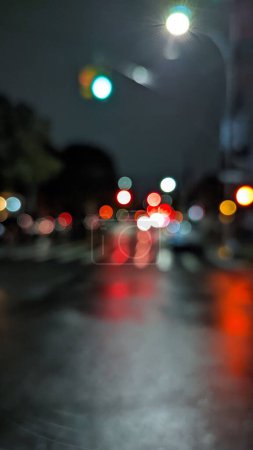 Photo for A blurry vertical view of traffic lights illuminating the street at rainy night in New York - Royalty Free Image