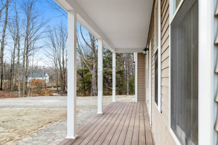 Téléchargez les photos : Le porche d'une maison contemporaine et moderne de style ranch dans la campagne avec terrasse marron - en image libre de droit