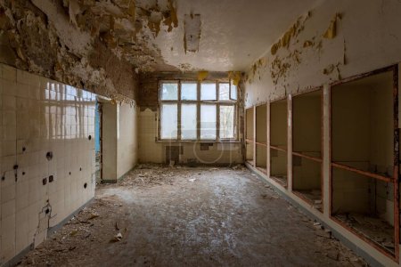 Téléchargez les photos : Une vue en bas du couloir dans un bâtiment abandonné avec de la peinture étalée sur les murs - en image libre de droit