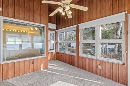 Téléchargez les photos : Les arbres forestiers visibles à travers les grandes fenêtres à l'intérieur de la maison au bord du lac - en image libre de droit