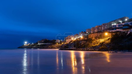Photo for A coastal town at night with reflections in the water - Royalty Free Image