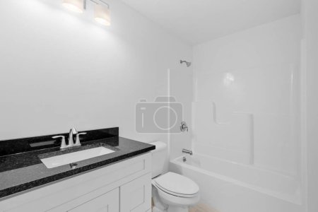 Foto de Un cuarto de baño moderno blanco con un baño y lavabo de mármol - Imagen libre de derechos