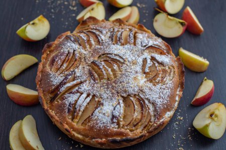 Téléchargez les photos : Plan rapproché d'une tarte aux pommes décorée de morceaux de fruits sur fond noir - en image libre de droit