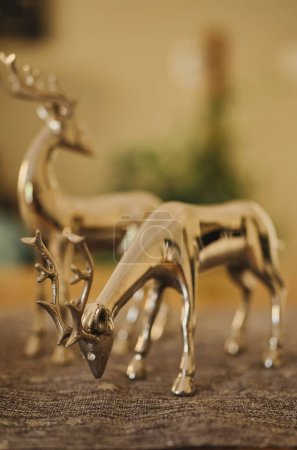 Photo for A vertical shot of golden reindeers as toys for christmas on a blurred background - Royalty Free Image
