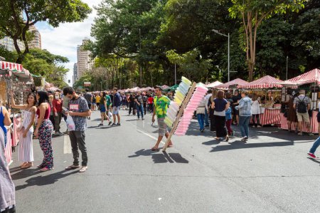 Foto de Un vendedor ambulante de algodón de azúcar con un grupo de personas comprando en la Avenida Afonso Pena en Belo Horizonte - Imagen libre de derechos