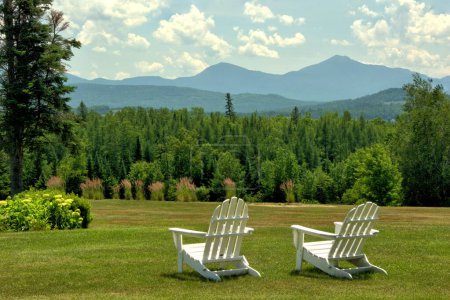 Téléchargez les photos : Vista pittoresque à Whitefield, New Hampshire. Chaises de pelouse surplombant la colline d'arbres luxuriants et de montagnes à feuilles persistantes dans la chaîne présidentielle. - en image libre de droit