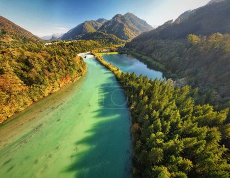 An aerial view of Steyr river flowing dense lush forests in Austria