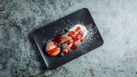 Foto de Una vista superior de delicioso syrniki cubierto con mermelada y frutas - Imagen libre de derechos