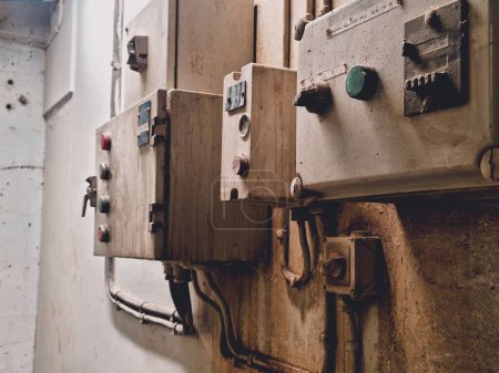 Foto de Un primer plano de viejo botón oxidado en una fábrica con paredes gruesas texturizadas - Imagen libre de derechos