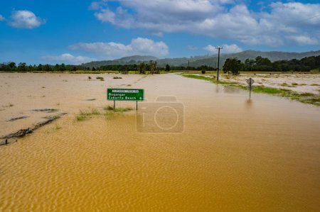 Téléchargez les photos : Un panneau vert dans l'eau. Inondation en Nouvelle-Galles du Sud, Australie. - en image libre de droit