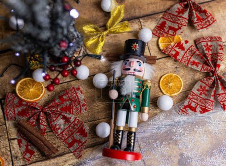 Téléchargez les photos : Une vue de dessus d'un jouet de casse-noix en bois sur la table avec des décorations de Noël - en image libre de droit