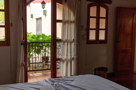 Téléchargez les photos : L'intérieur d'une pièce avec une porte ouverte menant au balcon - en image libre de droit