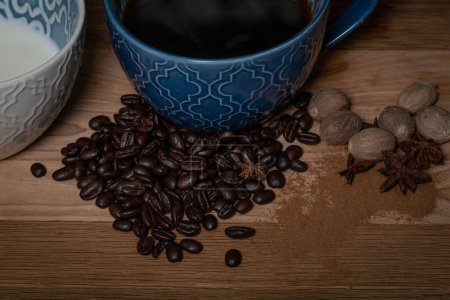 Téléchargez les photos : Café et crème dans des tasses assorties avec des grains de café et des épices sur une planche en bois - en image libre de droit