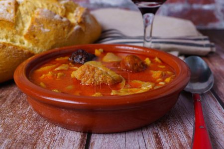 Téléchargez les photos : Casserole en terre cuite à la madrilène, cuisine typique espagnole sur une table en bois avec un mur de briques en arrière-plan. - en image libre de droit