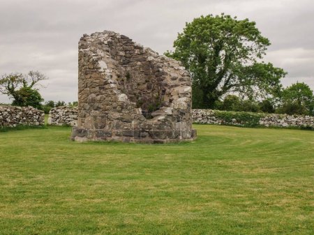 Téléchargez les photos : Une vue panoramique du site monastique de Nendrum sur la pelouse verte en Irlande du Nord par une journée nuageuse - en image libre de droit