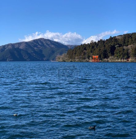 Foto de Lago azul abierto con pequeña puerta japonesa naranja en la isla frente. - Imagen libre de derechos