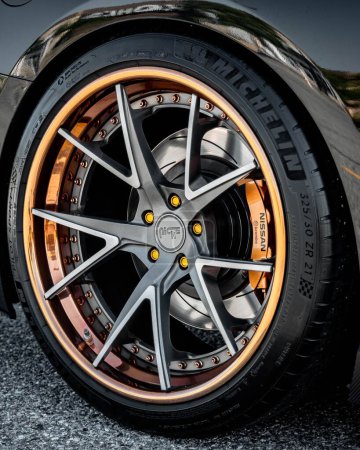 Photo for A vertical shot of a multi piece of gold and silver Wheel on a Nissan GTR - Royalty Free Image