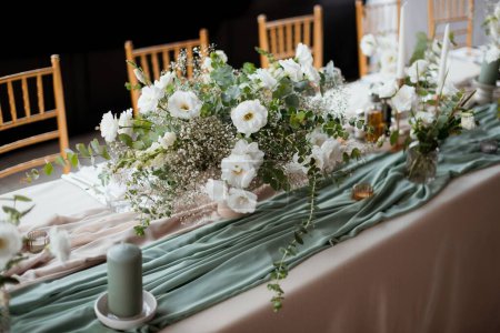 Foto de Una vista superior de una mesa bellamente decorada con ramos de flores blancas y sillas - Imagen libre de derechos