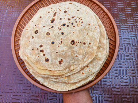 Téléchargez les photos : Chapati, également connu sous les noms roti, rotli, safati, shabaati, phulka, chapo, poli et roshi. Utilisation de farine de blé faire roti, dans le plat, utilisé quotidiennement manger en Inde - en image libre de droit