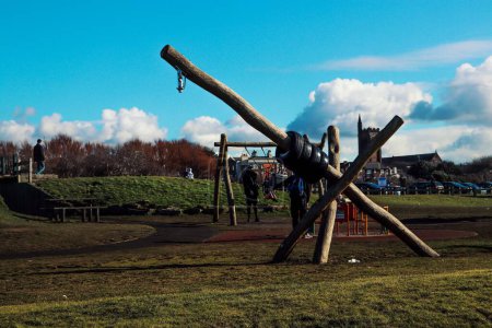 Photo for A landscape shot of a playground with wooden equipment under the cloudy blue sky in UK - Royalty Free Image