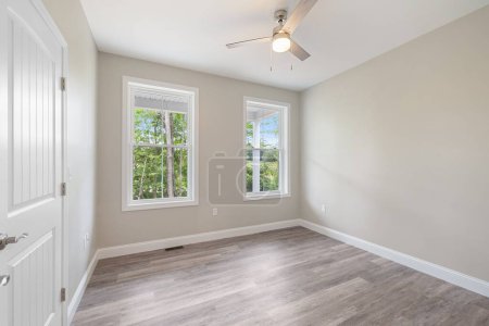 Téléchargez les photos : Un intérieur d'une chambre spacieuse avec des murs gris et parquet dans un style minimaliste - en image libre de droit