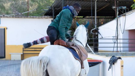 Téléchargez les photos : Un jockey masculin montant un cheval blanc pour s'entraîner - en image libre de droit