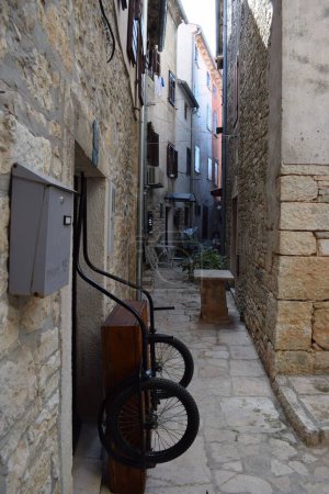 Foto de Dos monociclos sobre un soporte de madera en estrecho callejón rocoso con paredes de piedra - Imagen libre de derechos