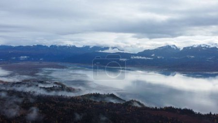 Téléchargez les photos : Brouillard sur l'océan avec des montagnes en arrière-plan - en image libre de droit