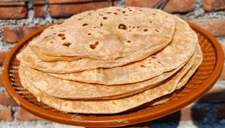 Foto de Chapati, también conocido como roti, rotli, safati, shabaati, phulka, chapo, poli y roshi. Usando harina de trigo hacer roti, en el plato, se utiliza el consumo diario en la India - Imagen libre de derechos