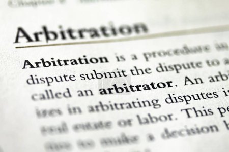A closeup of a legal textbook with a chapter about arbitration and arbitrators in focus